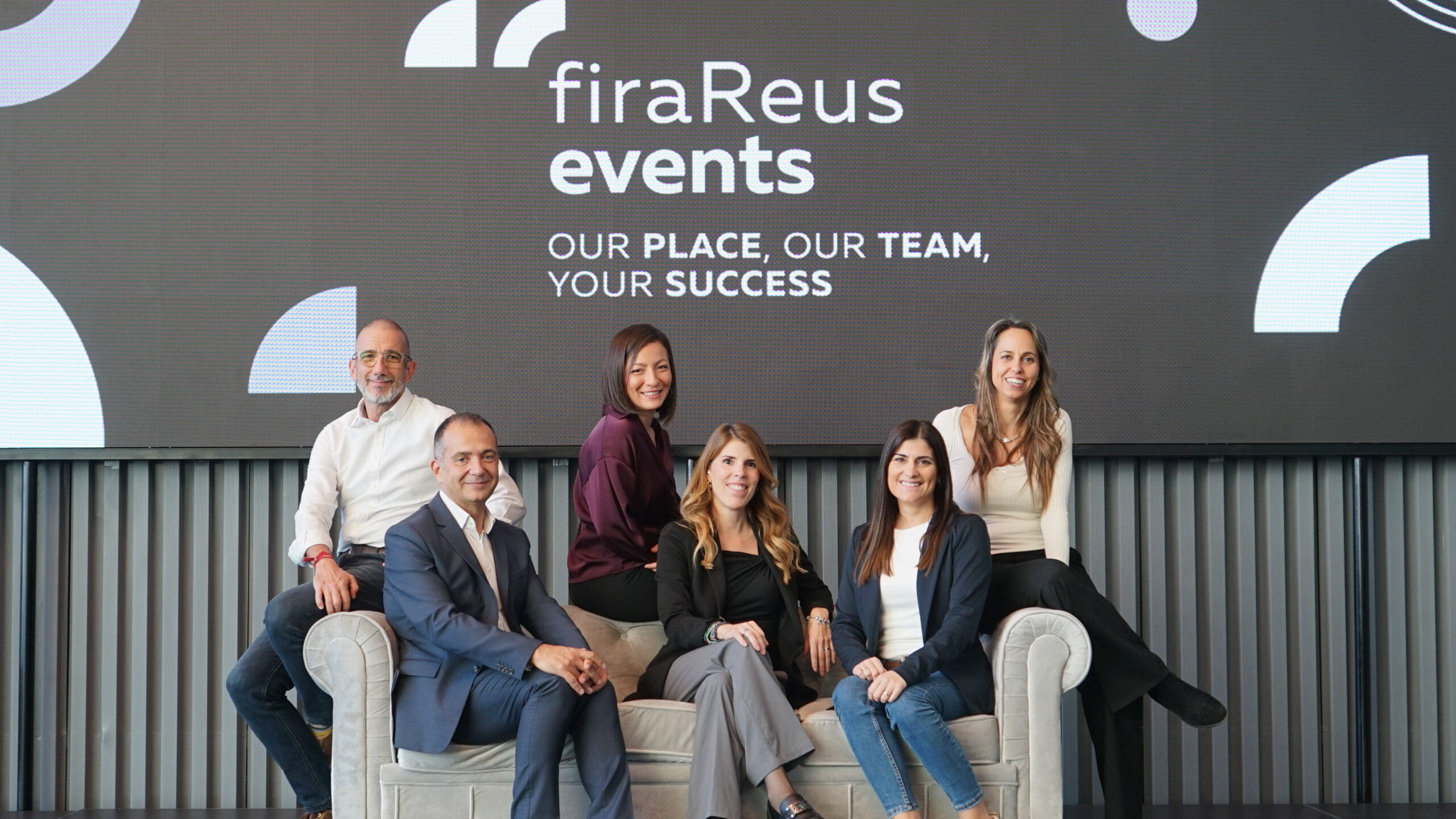 Fotografia de la imatge de cap&ccedil;alera, surt un grup de persones amb les mans al centre